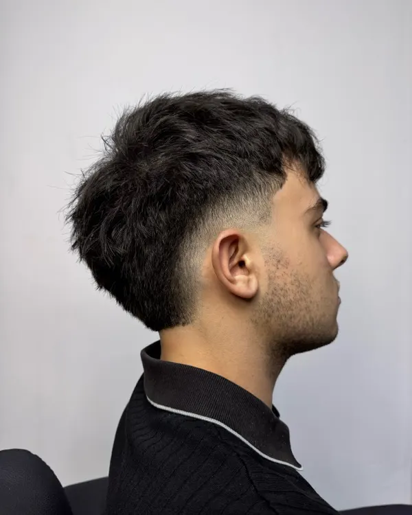 Siyah dokulu bol crop, yandan profil; kulak üstünde keskin fade, dolgun tepe