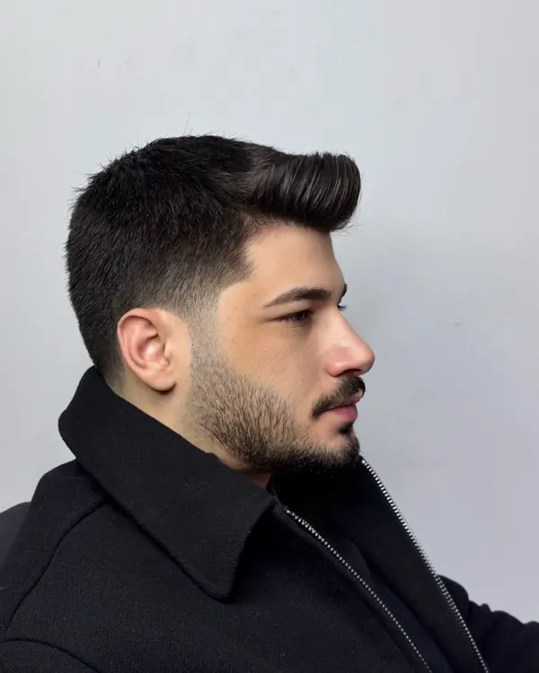 Belirgin pompadour, yandan görünüm; keskin şakak geçişi ve şekillendirilmiş dolgun sakal